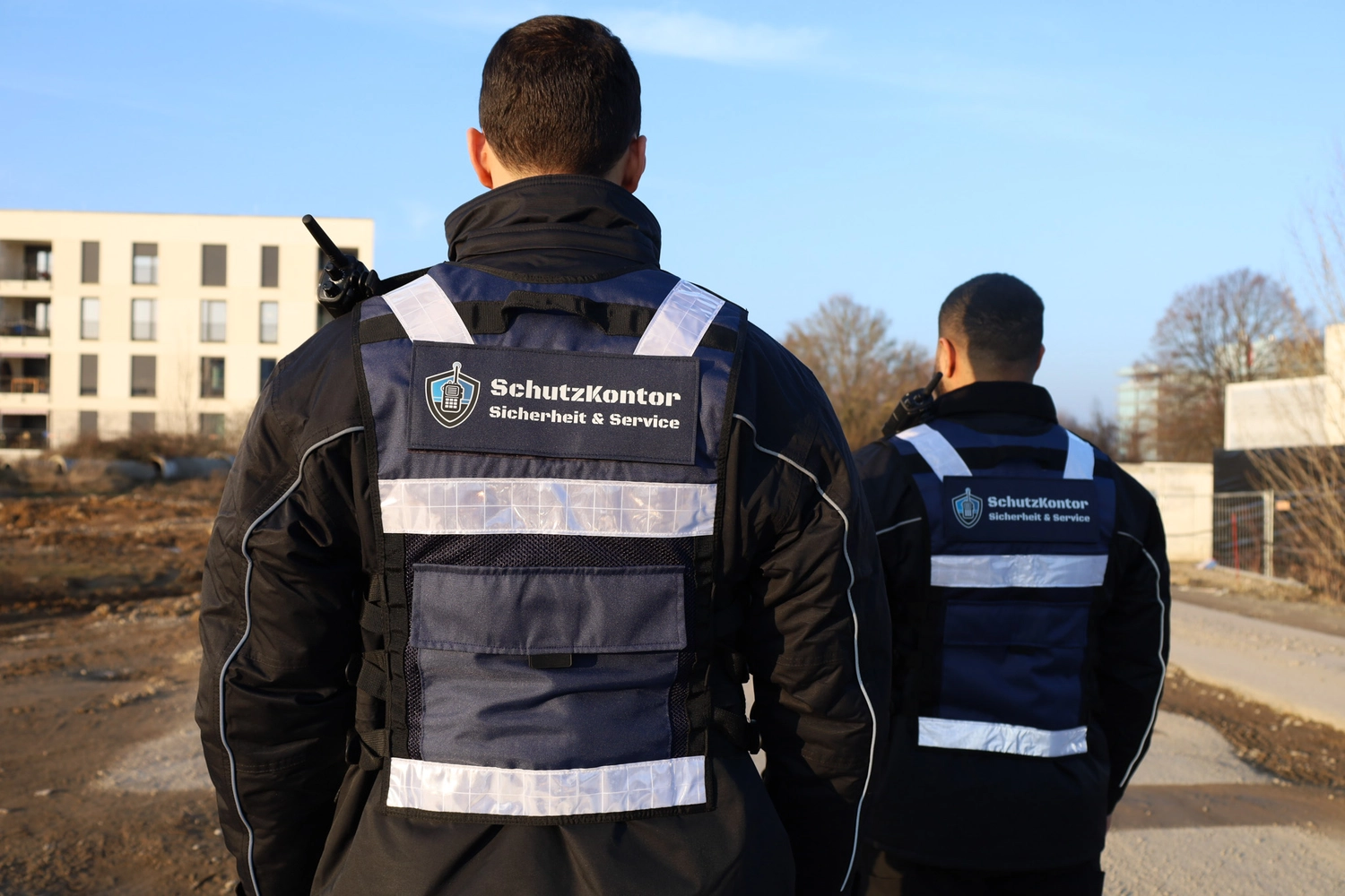 Schutzkontor Service GmbH - Sicherheitsdienst - Männlicher Sicherheitsbeamter in Uniform vor dunklem Hintergrund, Nahaufnahme