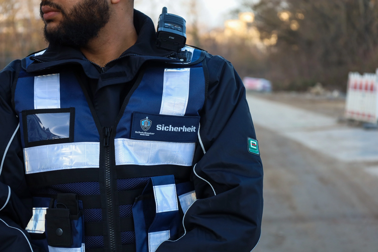 Schutzkontor Service GmbH - Sicherheitsdienst - Hand eines Geschäftsmannes, der ein Smartphone mit den Symbolen für Mobiltelefon, E-Mail, Telefon und Adresse hält.