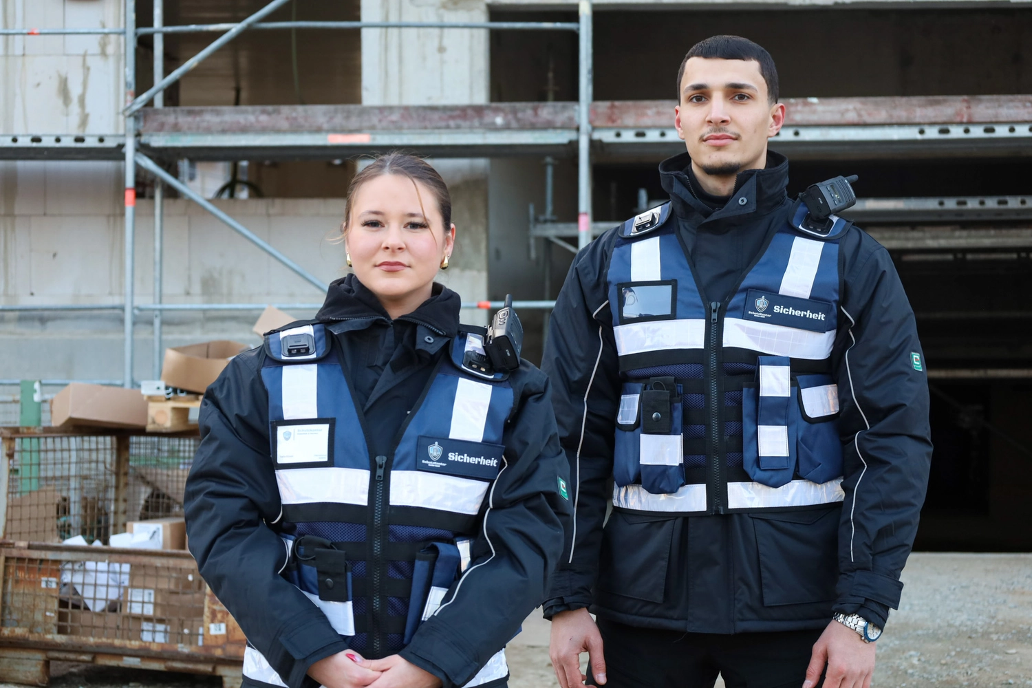 Schutzkontor Service GmbH - Sicherheitsdienst - Männlicher Wachmann benutzt im Freien ein tragbares Funkgerät