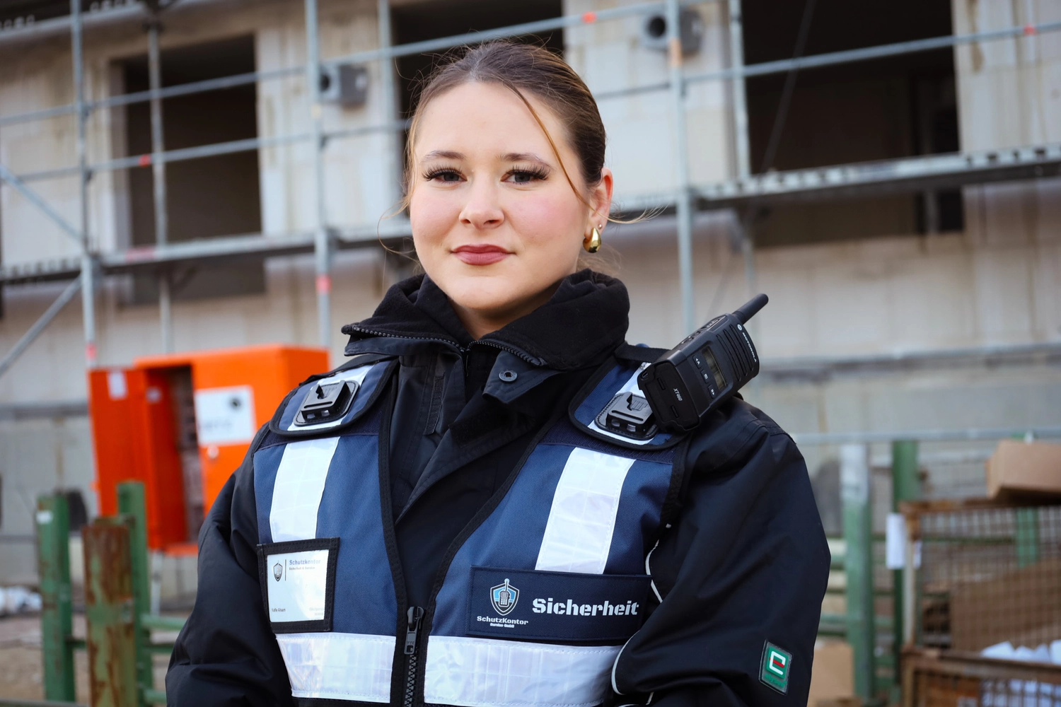 Schutzkontor Service GmbH - Sicherheitsdienst - Ein ernst dreinblickender Bodyguard mit Sonnenbrille und Sicherheits-Ohrhörer steht auf dem Hubschrauberlandeplatz.
