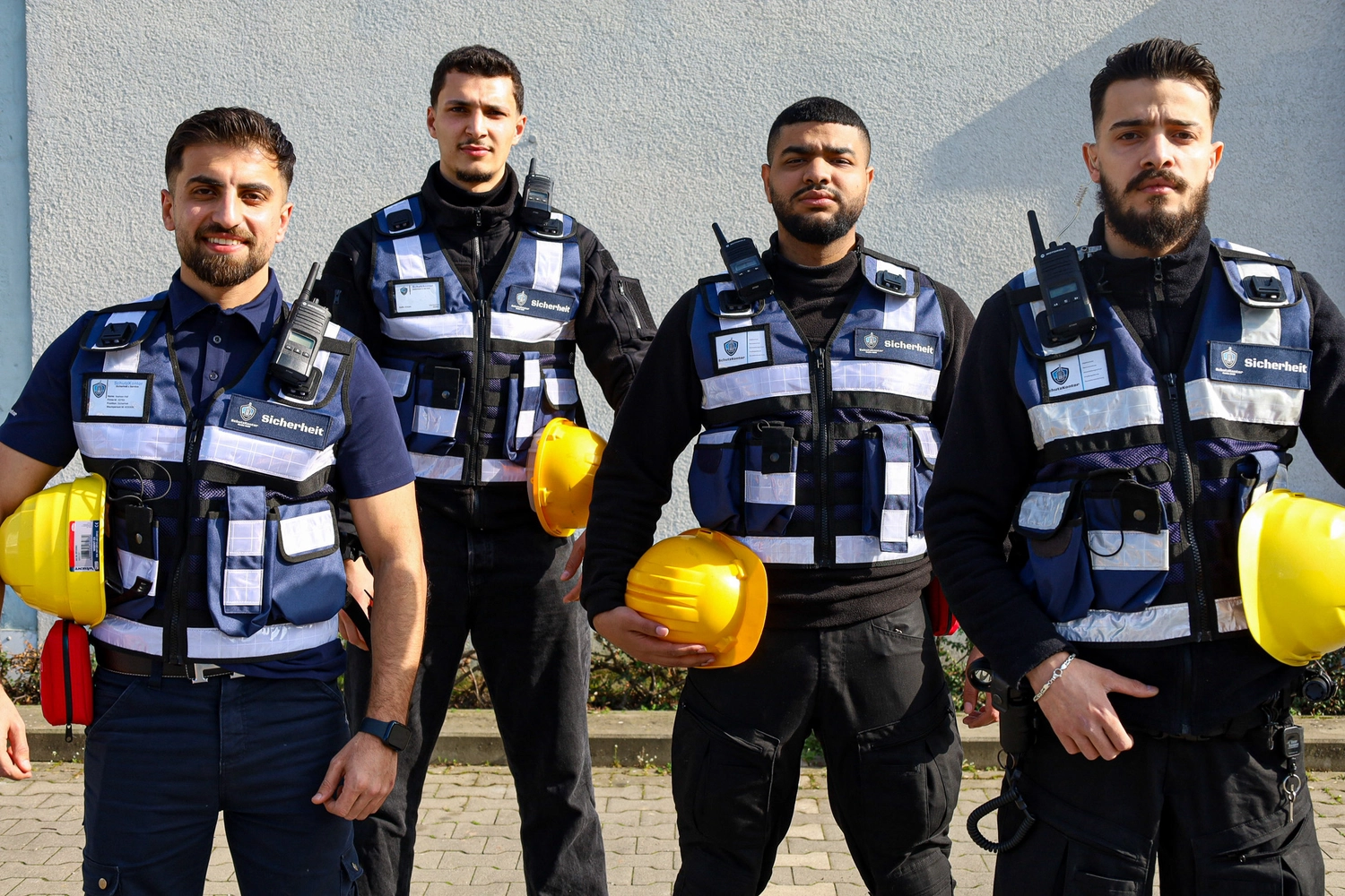 Schutzkontor Service GmbH - Sicherheitsdienst - Männlicher Wachmann benutzt im Freien ein tragbares Funkgerät