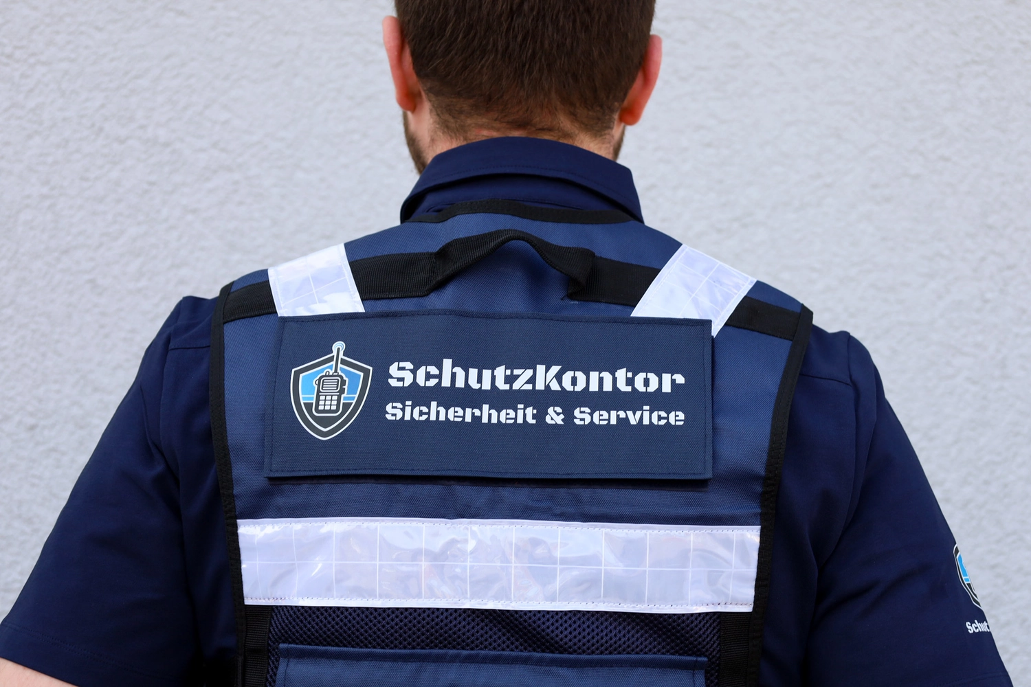Schutzkontor Service GmbH - Sicherheitsdienst - Männlicher Wachmann mit Taschenlampe auf einer Treppe im Dunkeln