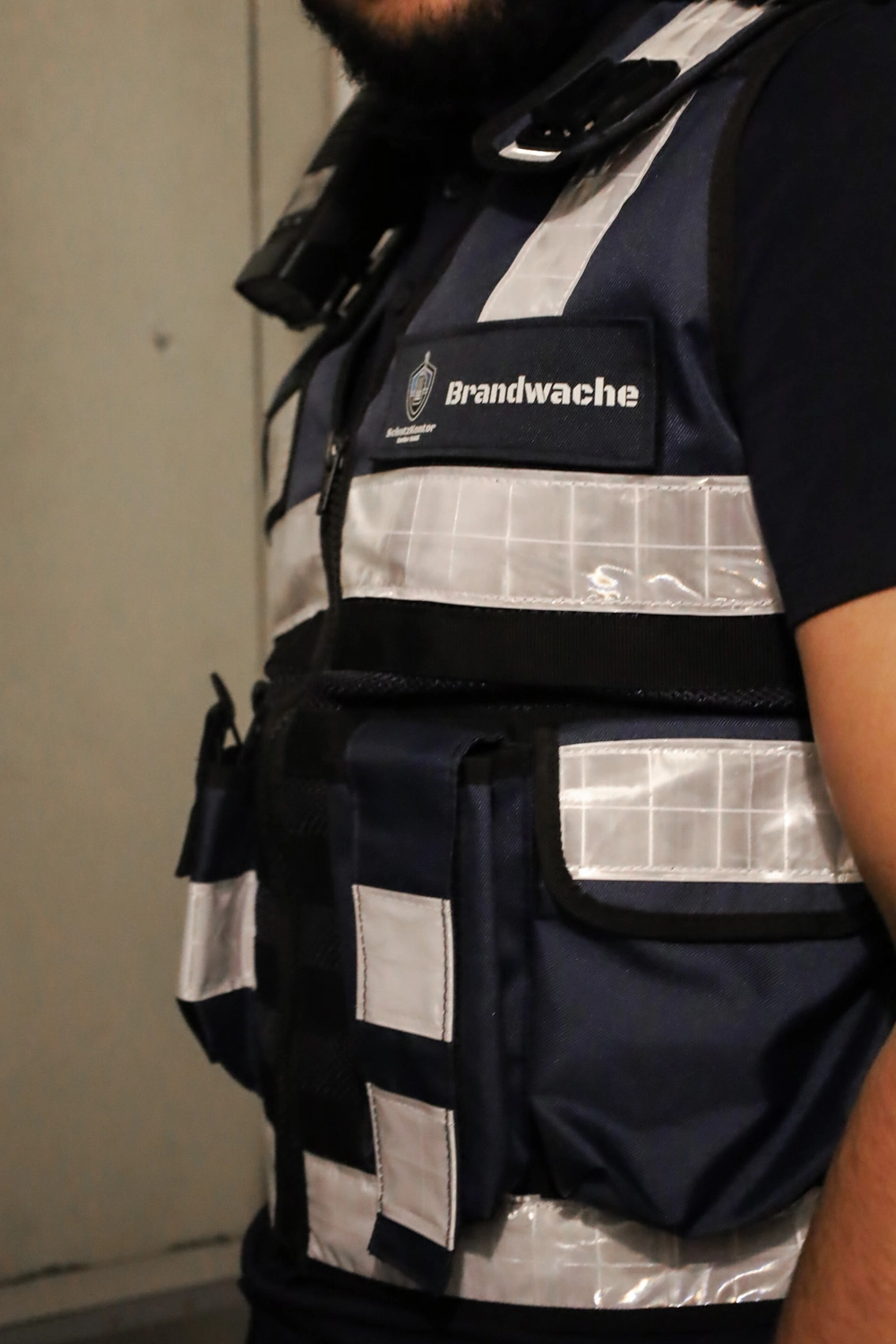 Schutzkontor Service GmbH - Sicherheitsdienst - Männlicher Wachmann mit Taschenlampe auf einer Treppe im Dunkeln